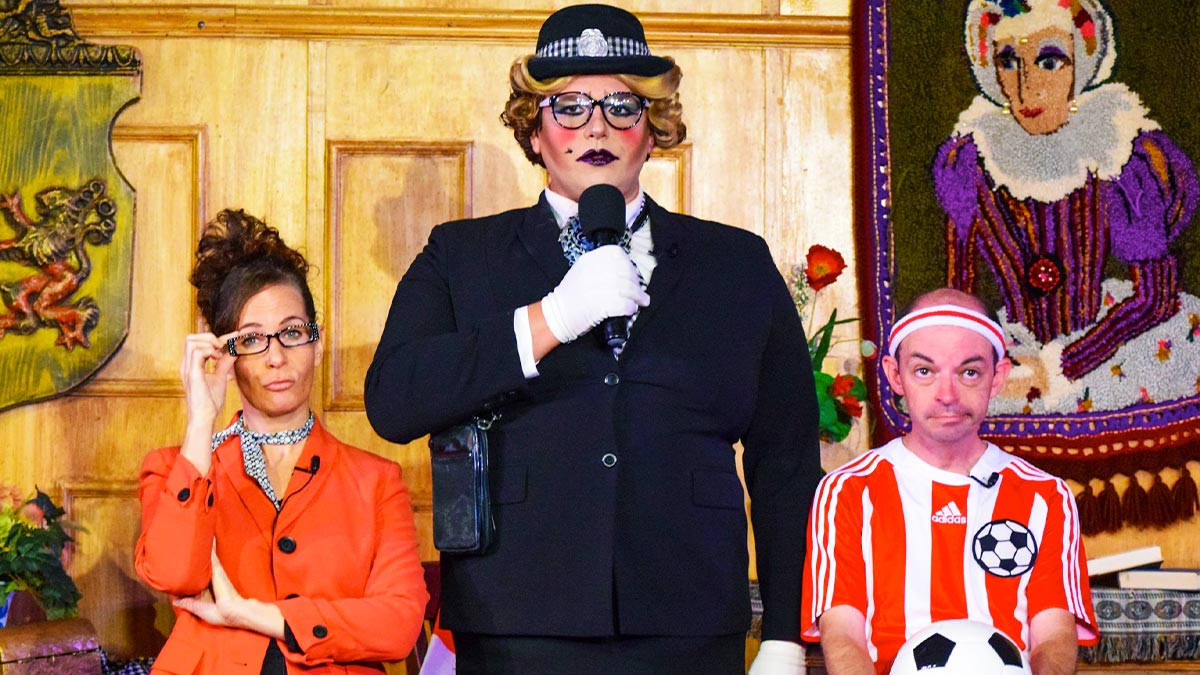 Three persons dressed as different people; the woman on the left appears to be a professor, the man on the right is dressed as a football player, and the middle man is wearing a tuxedo but wearing makeup.